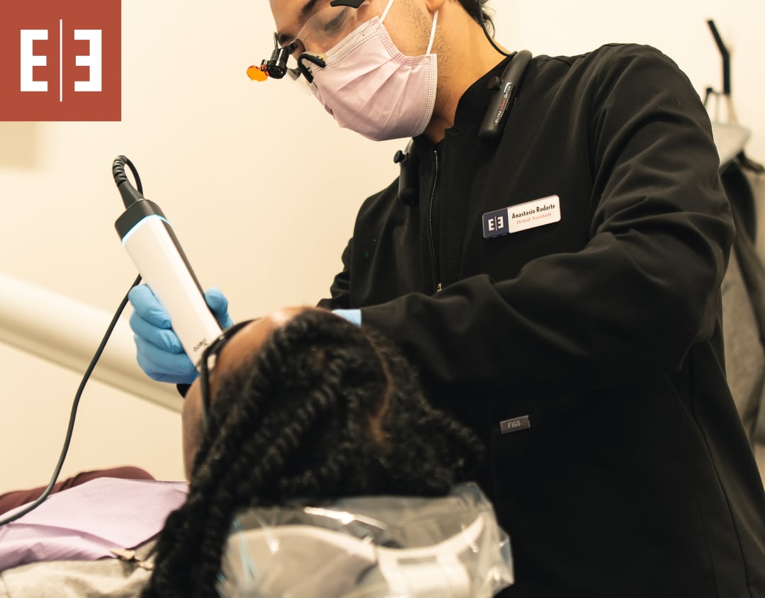 A close up of a young woman putting in clear retainers from esteem dental studio