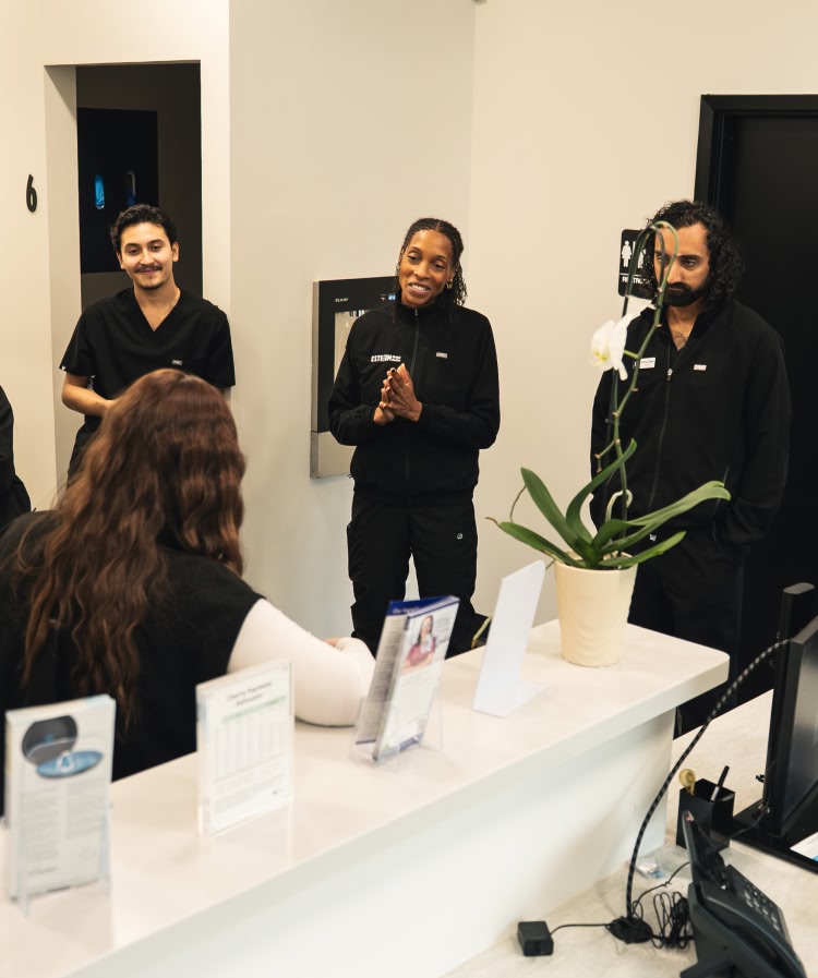 A young woman laying down in a dental chair smiling at esteem dental studio