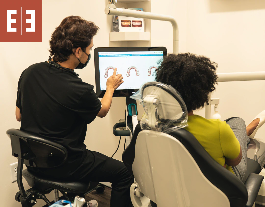 A close up of a young woman putting in clear retainers from esteem dental studio