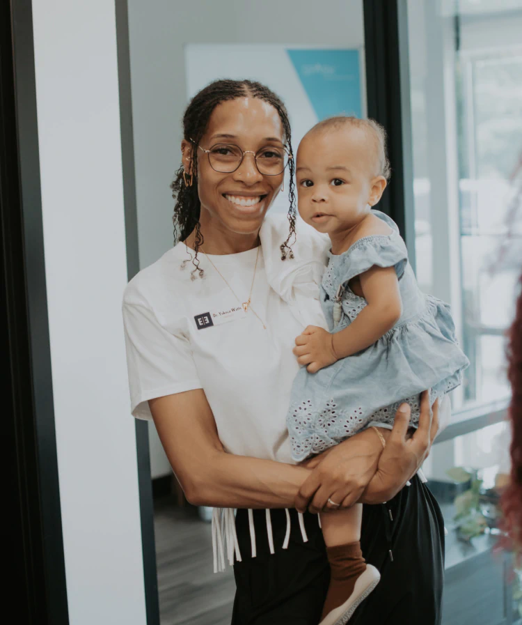 A young woman laying down in a dental chair smiling at esteem dental studio